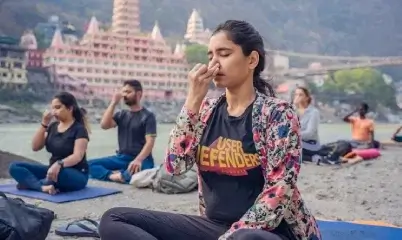 Group meditation on Ganga riverbank in Rishikesh